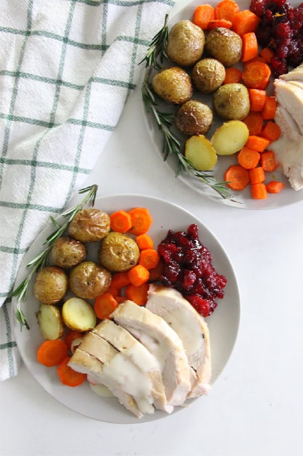 This Butter Rosemary Roasted Turkey will surely impress your guest! Cooked to perfection, this is moist buttery turkey with lots of flavor! Butter Rosemary Roasted Turkey on white plate with full meal