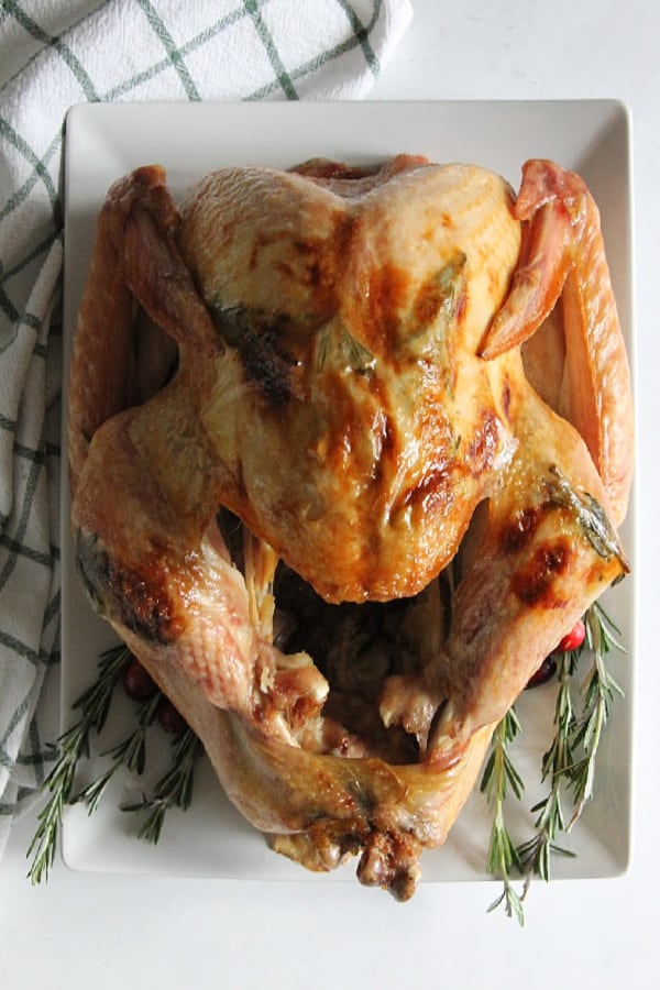 This Butter Rosemary Roasted Turkey will surely impress your guest! Cooked to perfection, this is moist buttery turkey with lots of flavor! | The Bitter Side of Sweet Butter Rosemary Roasted Turkey on white plate