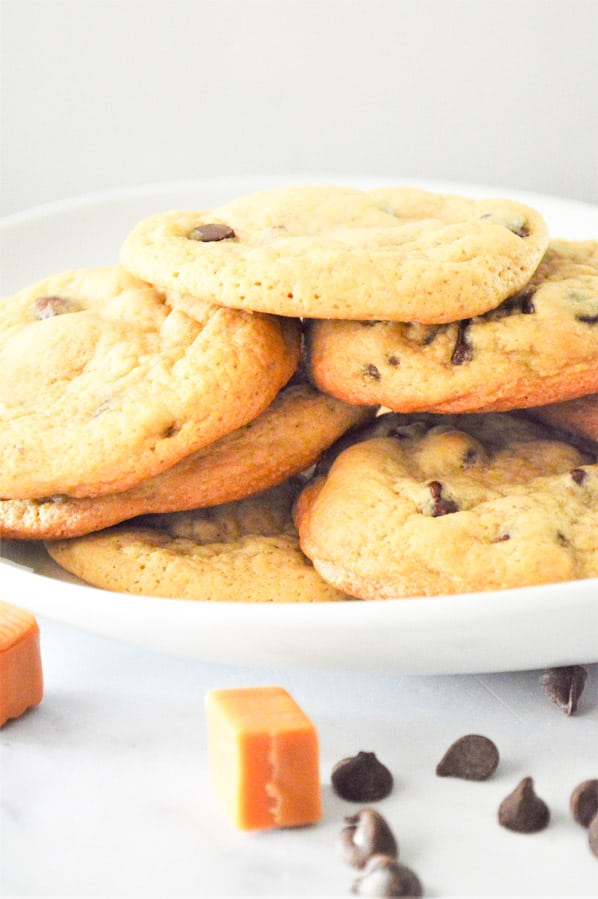 Ooey-gooey Chocolate Chip Caramel Cookies! Using a basic cookie recipe with a caramel stuffed inside for a delicious cookie! Chocolate Chip Caramel Cookies on plate