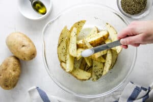potatoes in glass bowl adding salt.