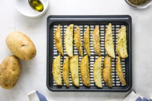 Air Fryer Parmesan Potato Wedges on crisper tray uncooked.