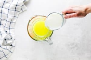 pouring milk into glass measuring cup.