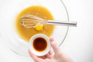 adding vanilla extract to mixing bowl.