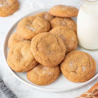 Ginger Molasses Cookies on white plate with milk.