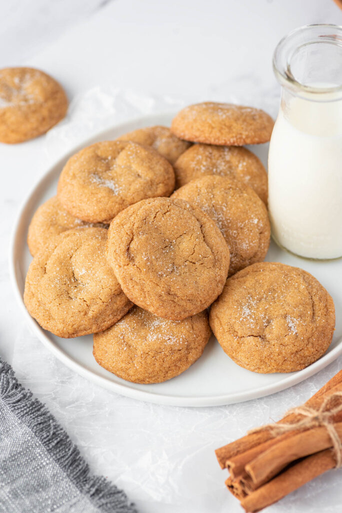 Soft and fluffy Ginger Molasses Cookies! WIth a delicious flavor these will be your new, favorite classic cookie to make! Ginger Molasses Cookies on white plate with milk.