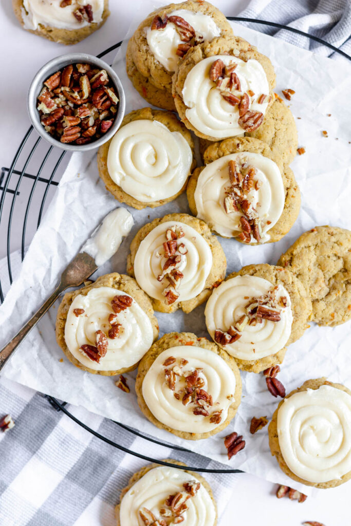 These carrot cake cookies are delicate and light! Topped with a fluffy creamy cheese frosting! Taste just like cake but easier to make! cookies topped with frosting and pecans.
