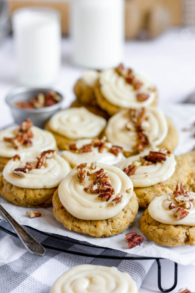 These carrot cake cookies are delicate and light! Topped with a fluffy creamy cheese frosting! Taste just like cake but easier to make! cookies topped with pecans.