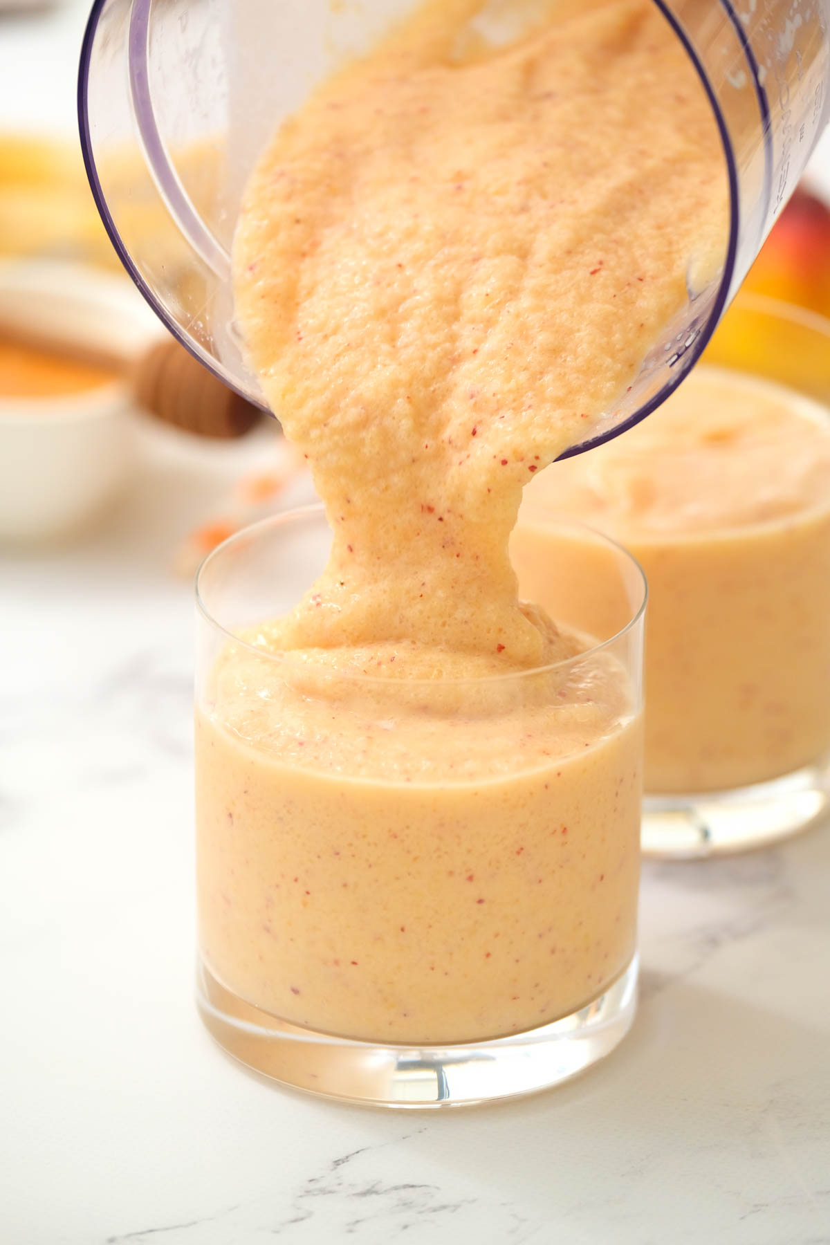 pouring smoothie into glass.