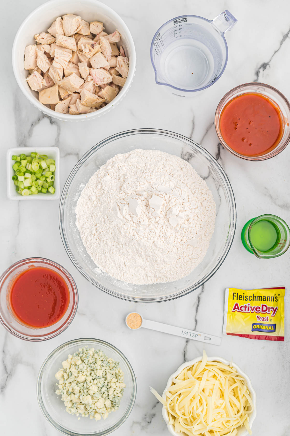 This easy buffalo chicken pizza starts with a homemade pizza dough, topped with chicken, blue cheese, and green onions. Buffalo Chicken Pizza ingredients.