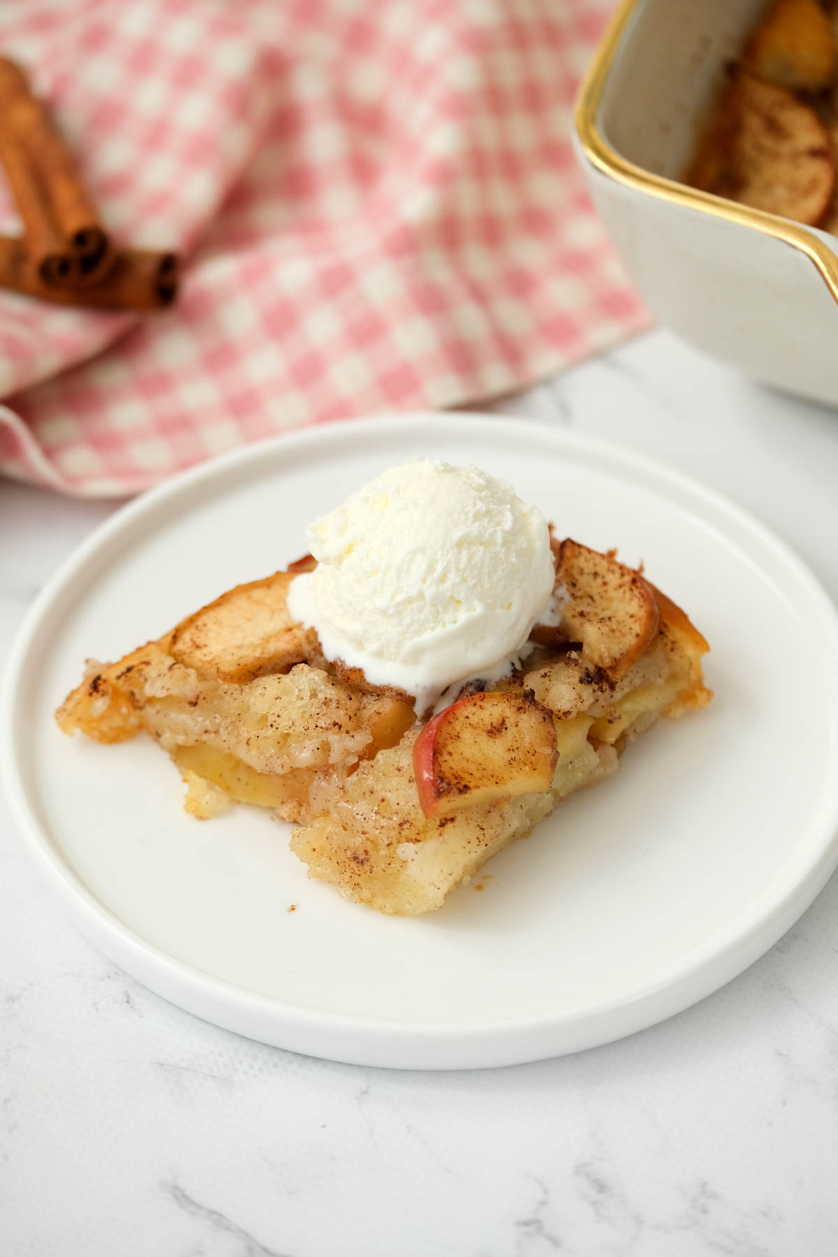 Easy Apple Cobbler that is so simple to make! Filled with the warm spice of cinnamon, embedded in a cake-like buttery topping! cobbler topped with ice cream.