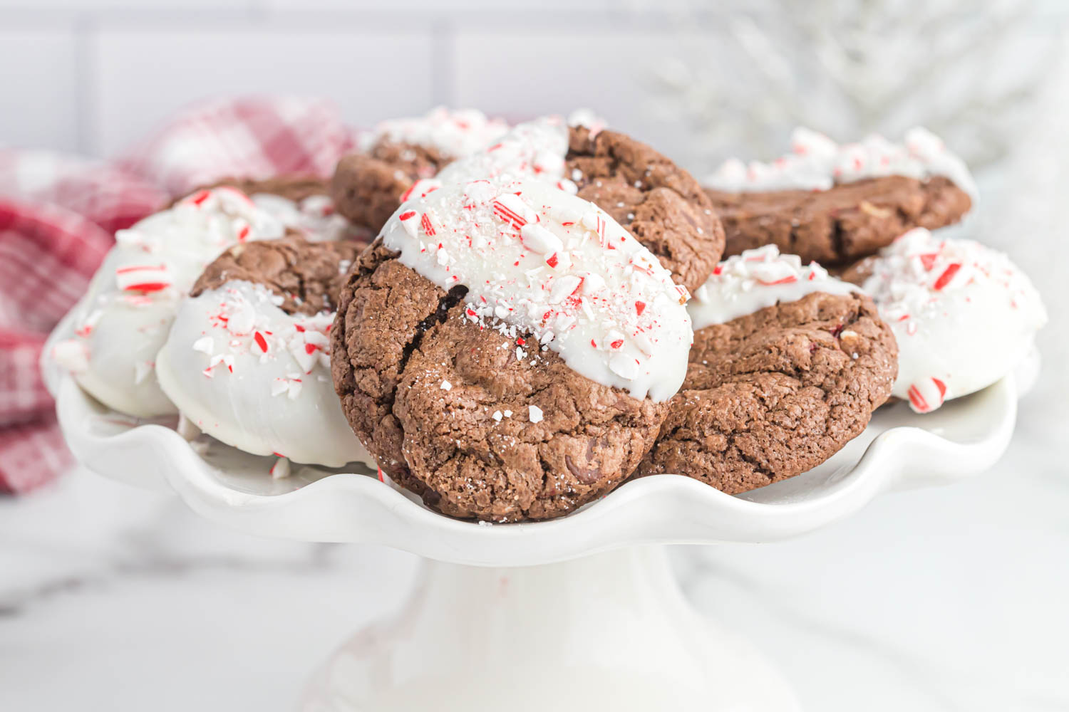Chocolate Peppermint Bark Cookies dipped in white chocolate sprinkled with crushed candy cane.