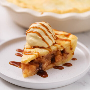simple apple pie on white plate with caramel drizzle
