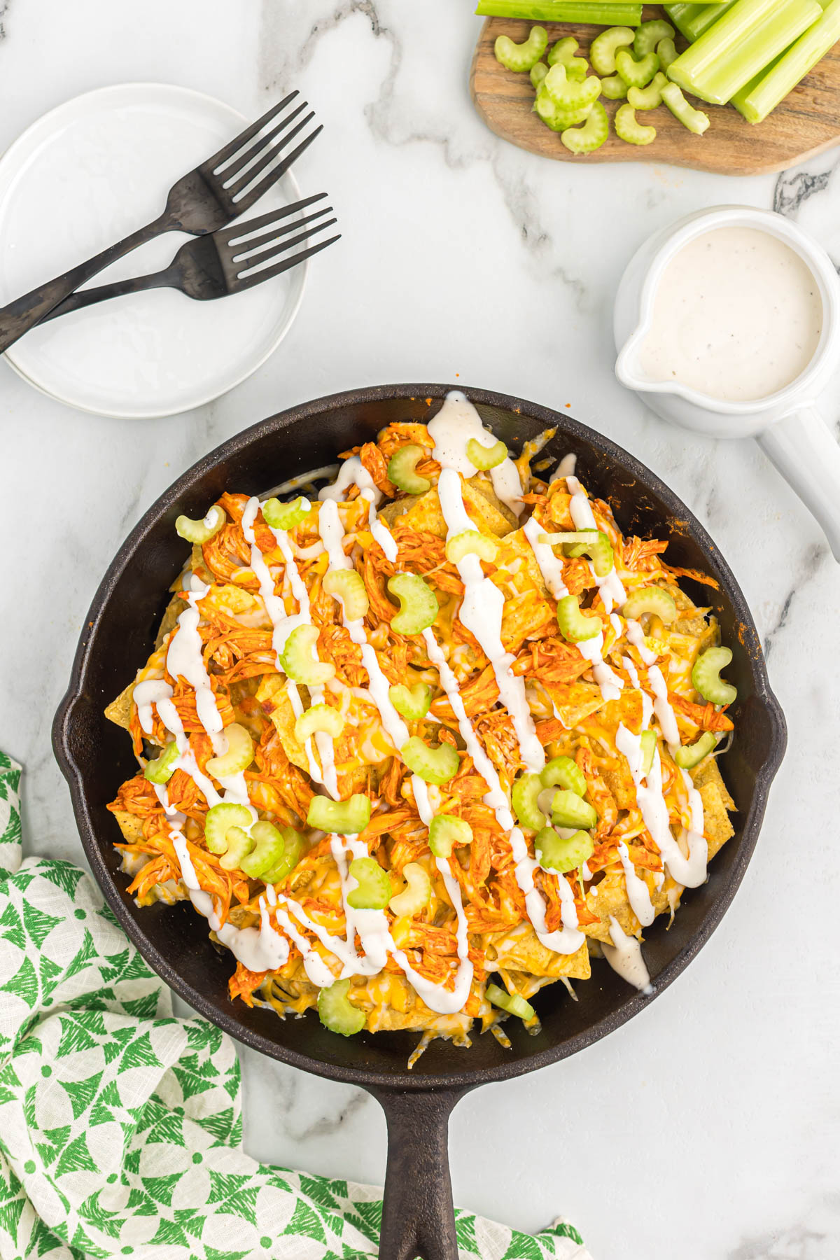 Easy to make Buffalo Chicken Skillet Nachos. Made with rotisserie chicken and buffalo sauce, this will become your new game day appetizer! overhead view of buffalo chicken skillet nachos