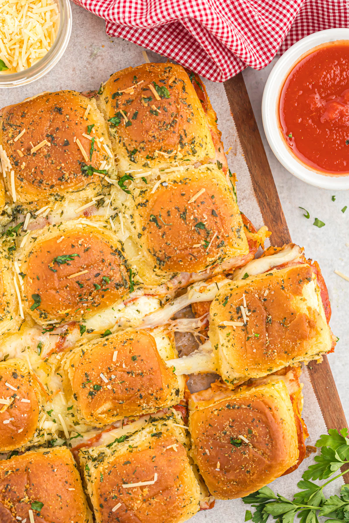 Craving pizza without the mess? Bite-sized pepperoni pizza sliders are the answer! Fluffy slider rolls meet melty cheese, tomato sauce, and pepperoni for an irresistible finger food. Perfect for game days, parties, or a quick and easy weeknight meal. piece of pizza slider with stringy cheese
