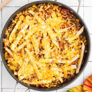 Taco skillet in pan topped with cheese.