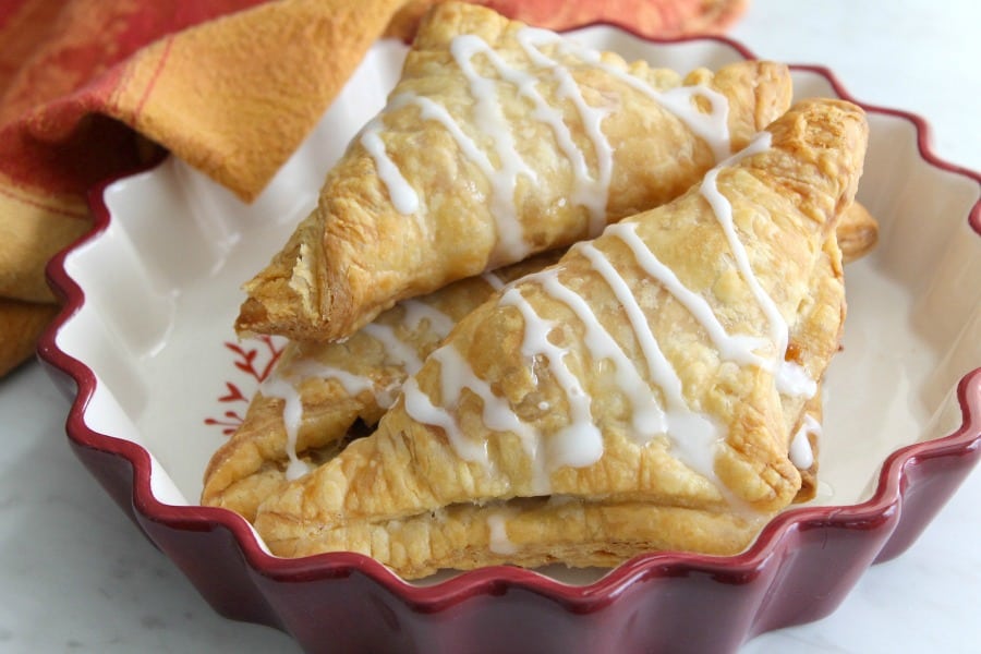 Pumpkin Pie Turnovers stacked in red bowl with orange napkin