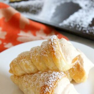 cream horns stacked on white plate.