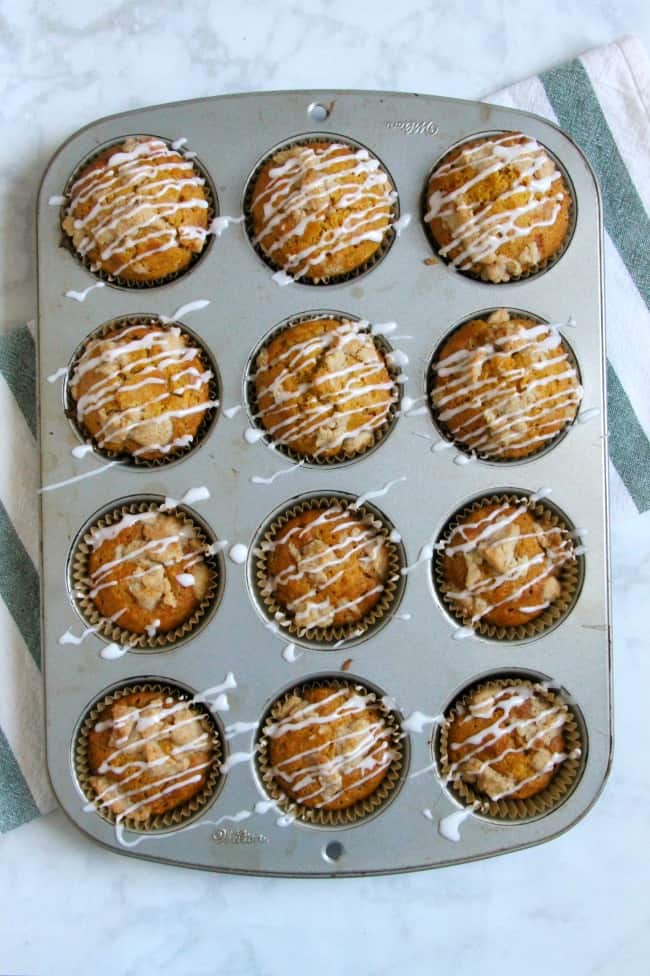 muffins in pan drizzled with icing.