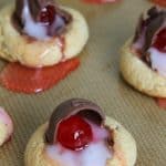 Chocolate Covered Cherry Thumbprint Cookies on brown background