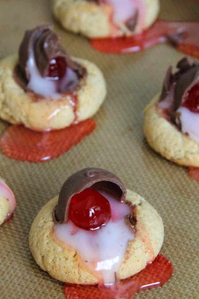 Chocolate Covered Cherry Thumbprint Cookies on brown background