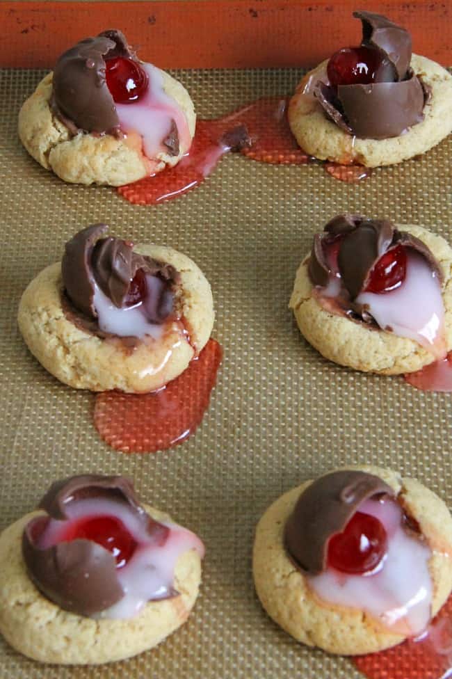 Chocolate Covered Cherry Thumbprint Cookies on brown background