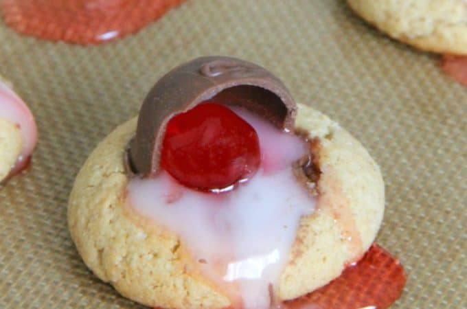 Chocolate Covered Cherry Thumbprint Cookies on brown background