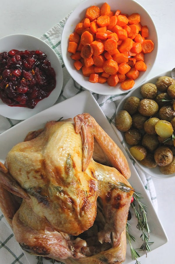 Butter Rosemary Roasted Turkey on white plate with full meal