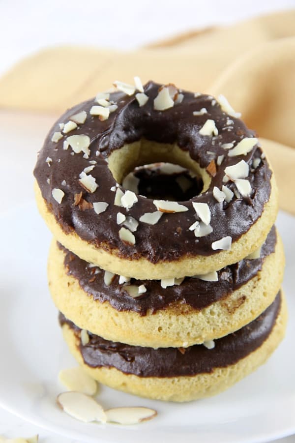 Chocolate Almond Glazed Donuts stacked on white plate
