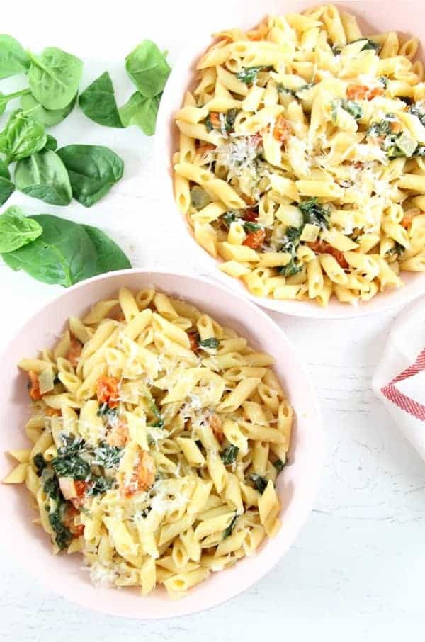 Creamy Tomato Spinach Pasta is what's for dinner tonight! It's full of fresh flavors, like tomato and spinach, and ready in minutes. Creamy Tomato Spinach Pasta in bowls
