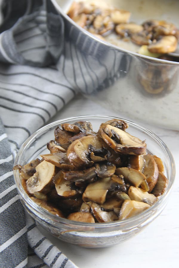 A simple guide on How To Saute Mushrooms! Goes perfect over pasta dishes, in risotto or on top of your favorite protein! So easy but so flavorful! How To Sauté Mushrooms in glass bowl