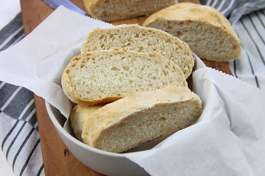 Homemade Italian Bread in gray bowl on brown cutting board