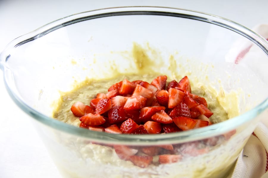 Strawberry Oatmeal Muffins mix in glass bowl with fresh strawberries