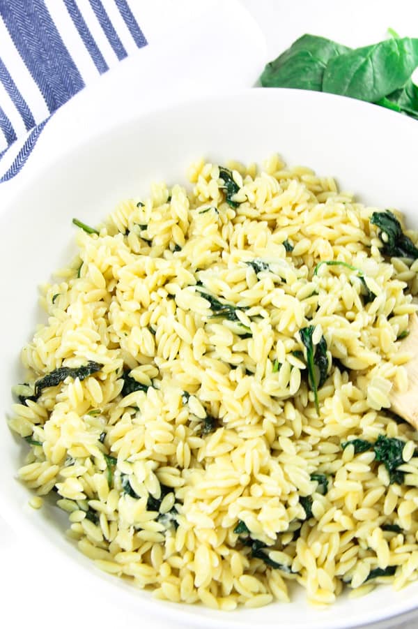 This Cheesy Spinach Orzo is an easy 20 minute meal! Made with fresh spinach, onions and garlic this tasty pasta is also loaded with freshly grated cheese!