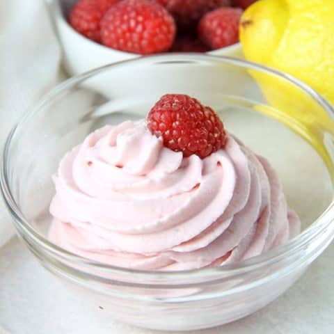 Lemon Raspberry Whipped Cream in glass bowl topped with fresh raspberry
