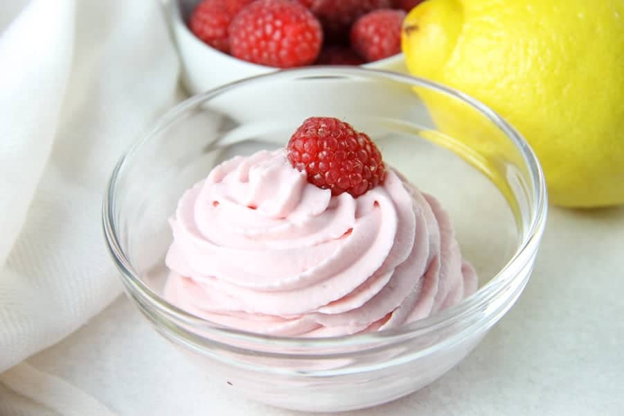 Lemon Raspberry Whipped Cream in glass bowl topped with fresh raspberry