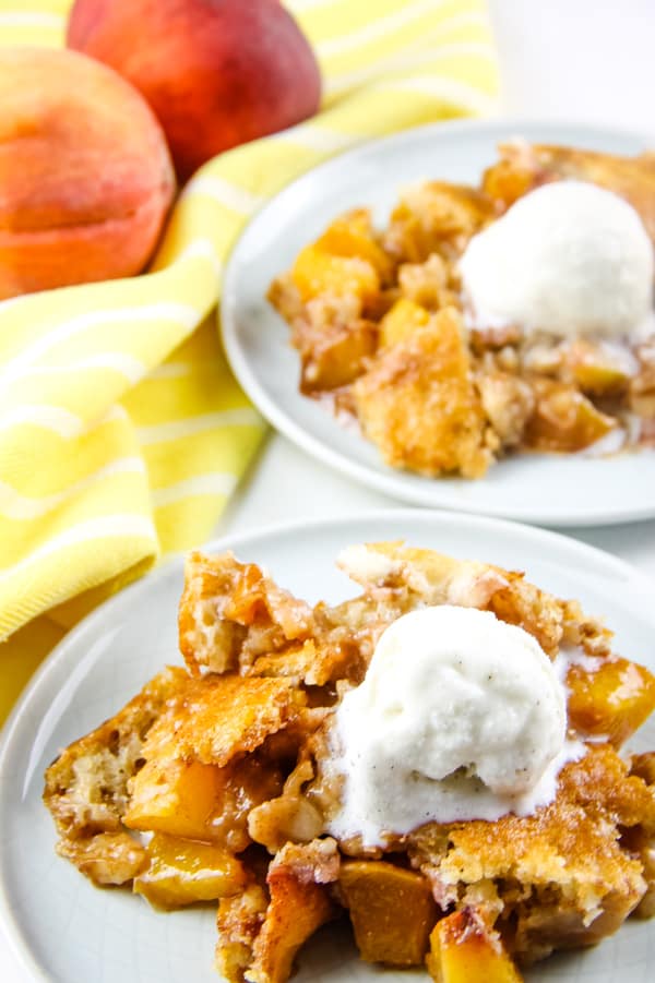 Peach Cobbler on plates with ice cream and peaches on top