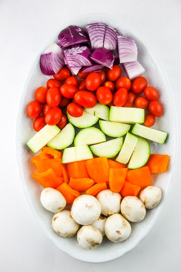 Grilled Vegetable Skewers with raw vegetables on white plate