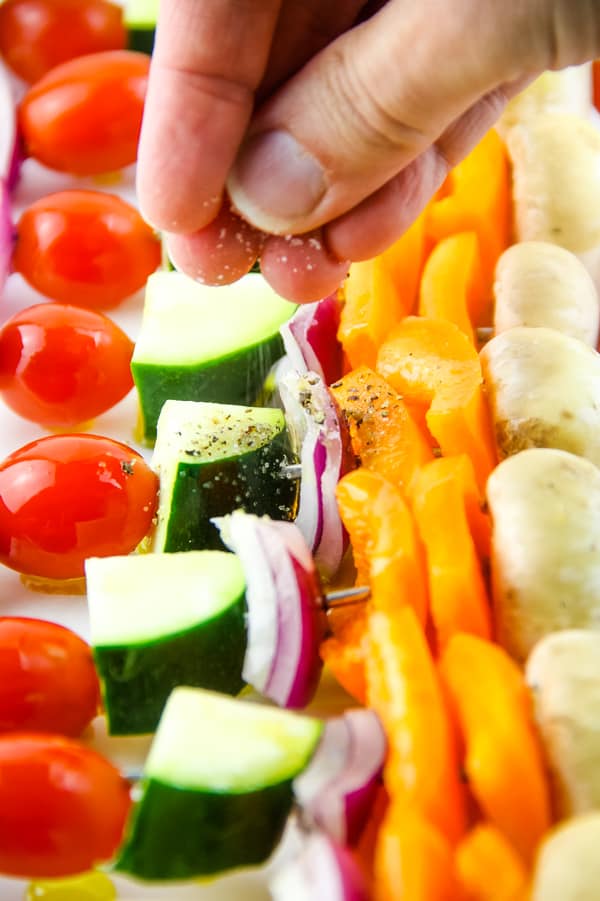 Grilled Vegetable Skewers with hand sprinkling on salt and pepper