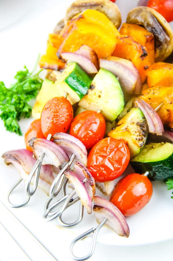 Grilled Vegetable Skewers on white plate with green parsley