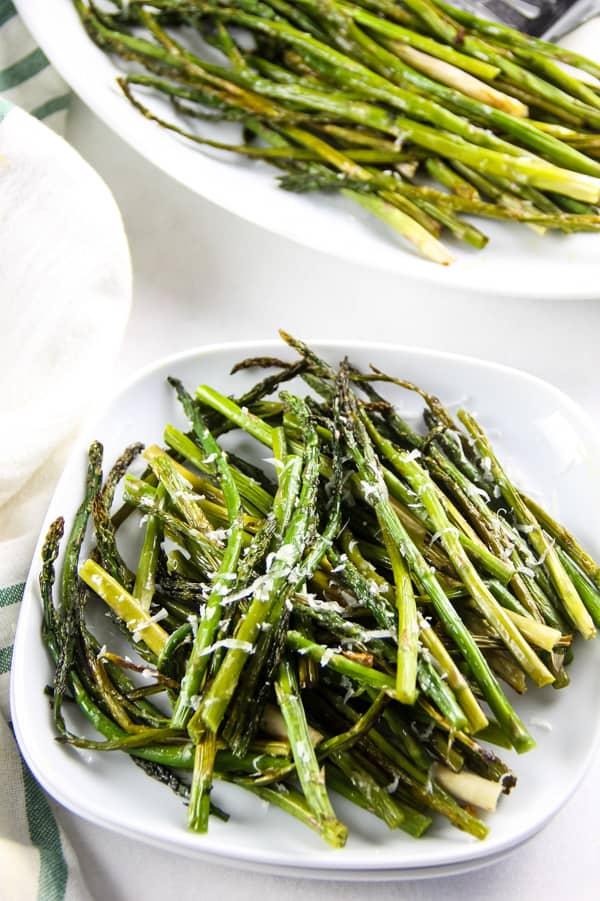 Sheet Pan Roasted Asparagus on small white plate cut into small pieces