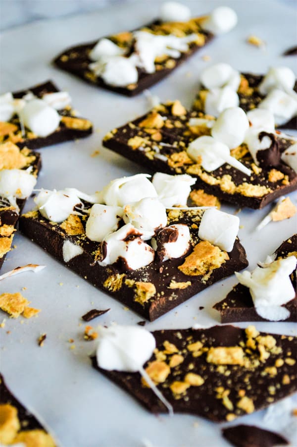 S'mores Bark on parchment paper with marshmallows on top