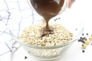 Chocolate Hazelnut Granola nutella being poured in bowl