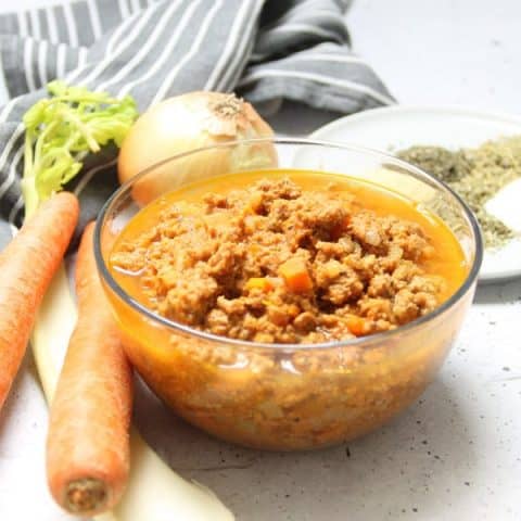 Instant Pot Turkey Ragu in glass bowl with ingredients in background