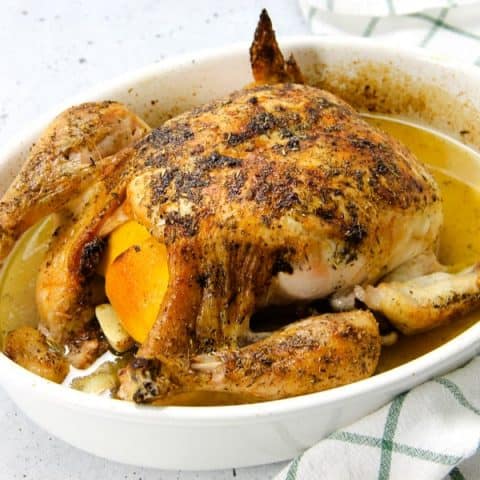 Oven Baked Whole Chicken in white baking dish