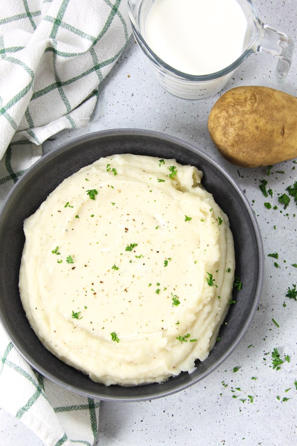 Pressure Cooker Potatoes with Gravy in gray bowl topped with parsley