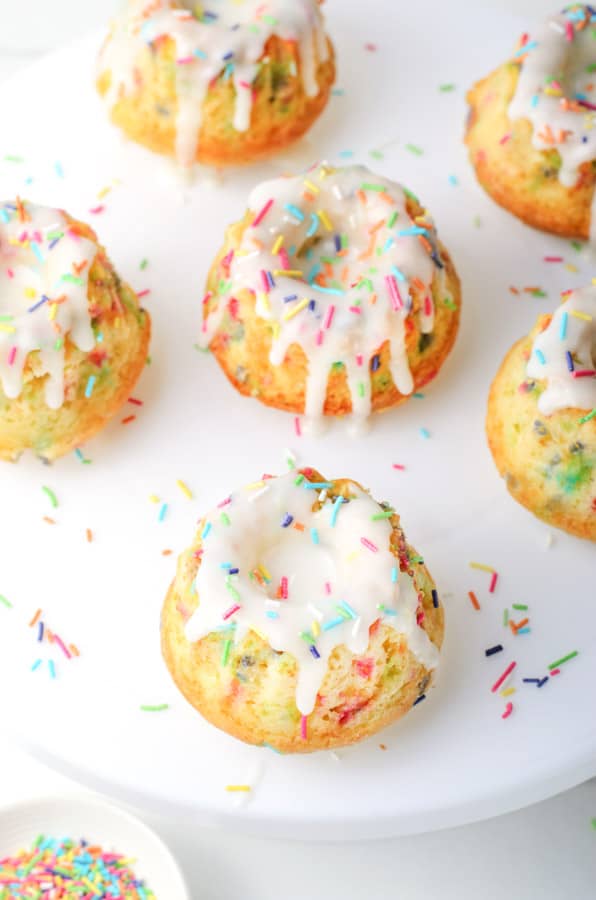 Funfetti Mini Bundt Cakes on white plate with sprinkles