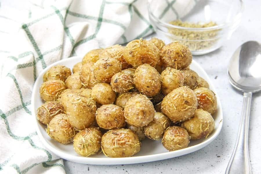 Roasted Rosemary Potatoes on white plate with spoon