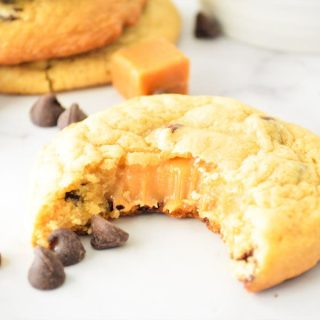 Chocolate Chip Caramel Cookies with bite and caramel oozing out