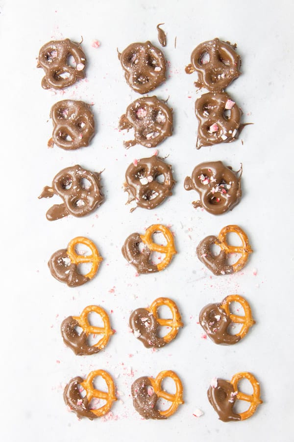 Pretzels covered in chocolate laid out on parchment paper