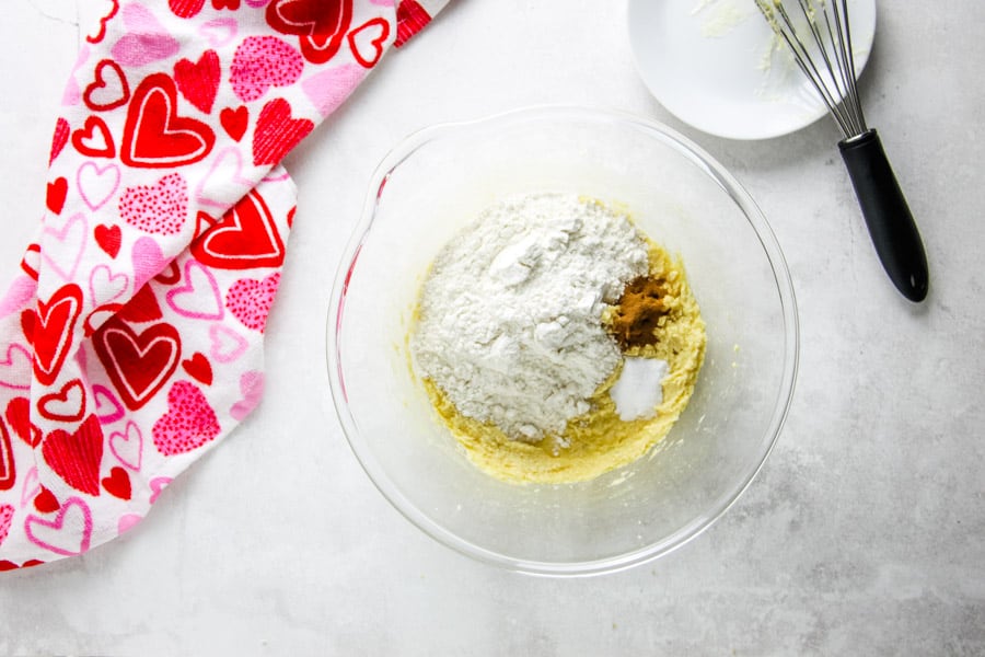 uncooked cookie ingredients in glass bowl with dry ingredients